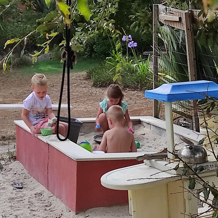 Peuter en kleuters spelen in de zandbak op hun portugese vakantie park