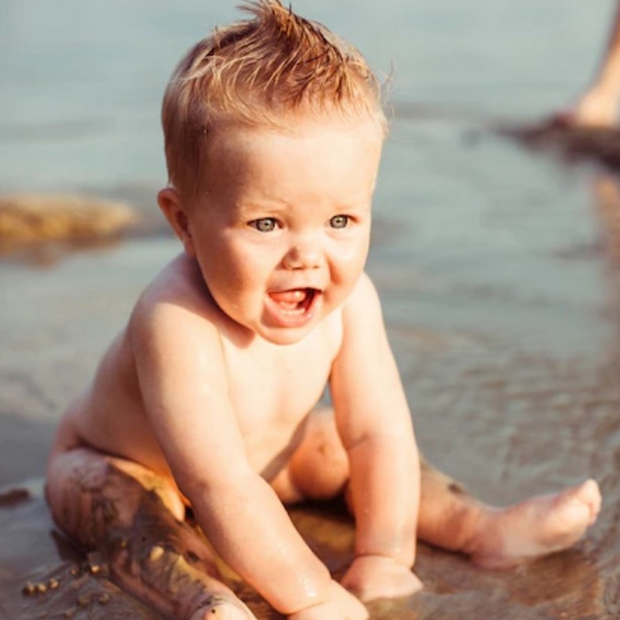 baby speelt in het strand zand tijdens je vakantie zilverkust in portugal